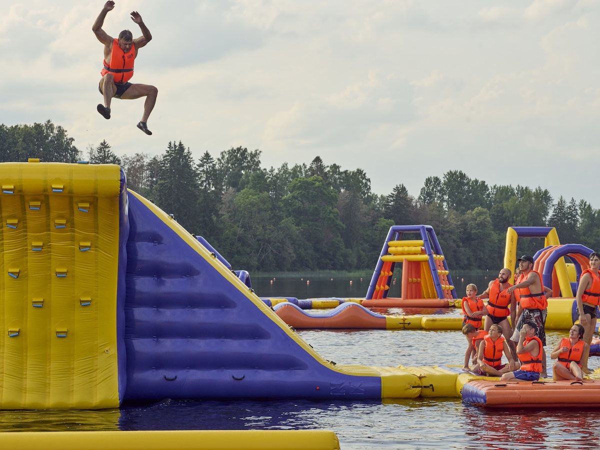 A visitor leaping at the Sportive Aqua inflatable water park on the lake in Brocēni