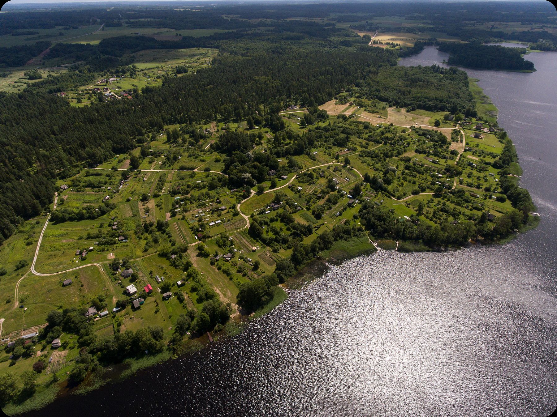 Aerial view of the Secret Trees Gardens property — a green headland reaching into Cieceres Lake